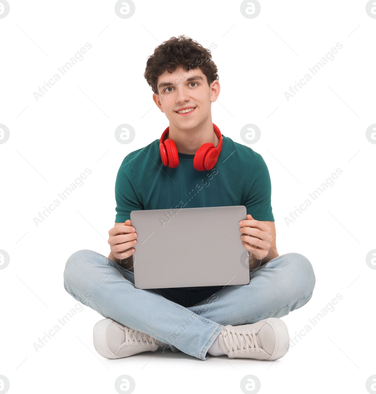 Photo of Portrait of student with laptop and headphones sitting on white background