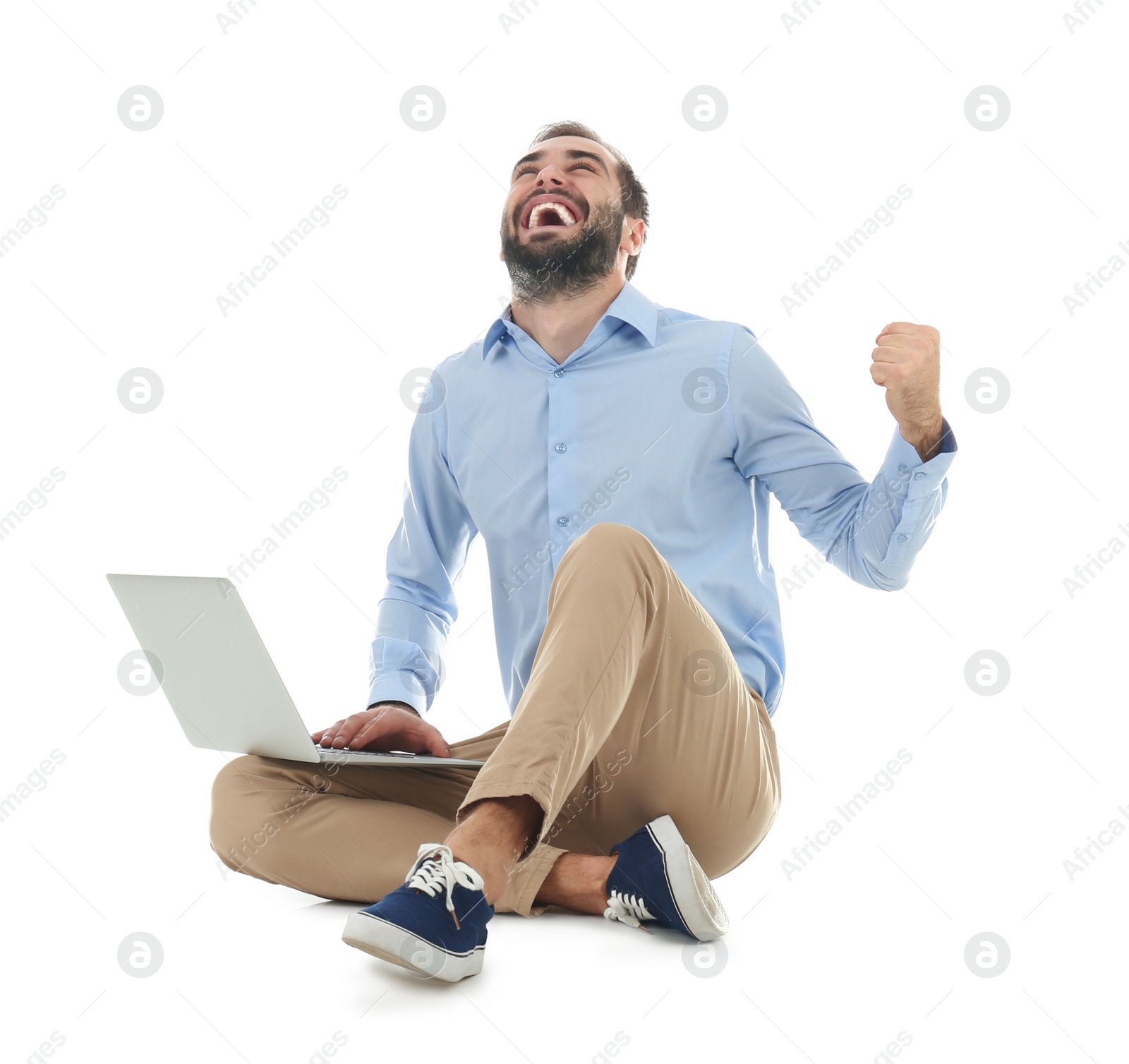 Photo of Emotional young man with laptop celebrating victory on white background