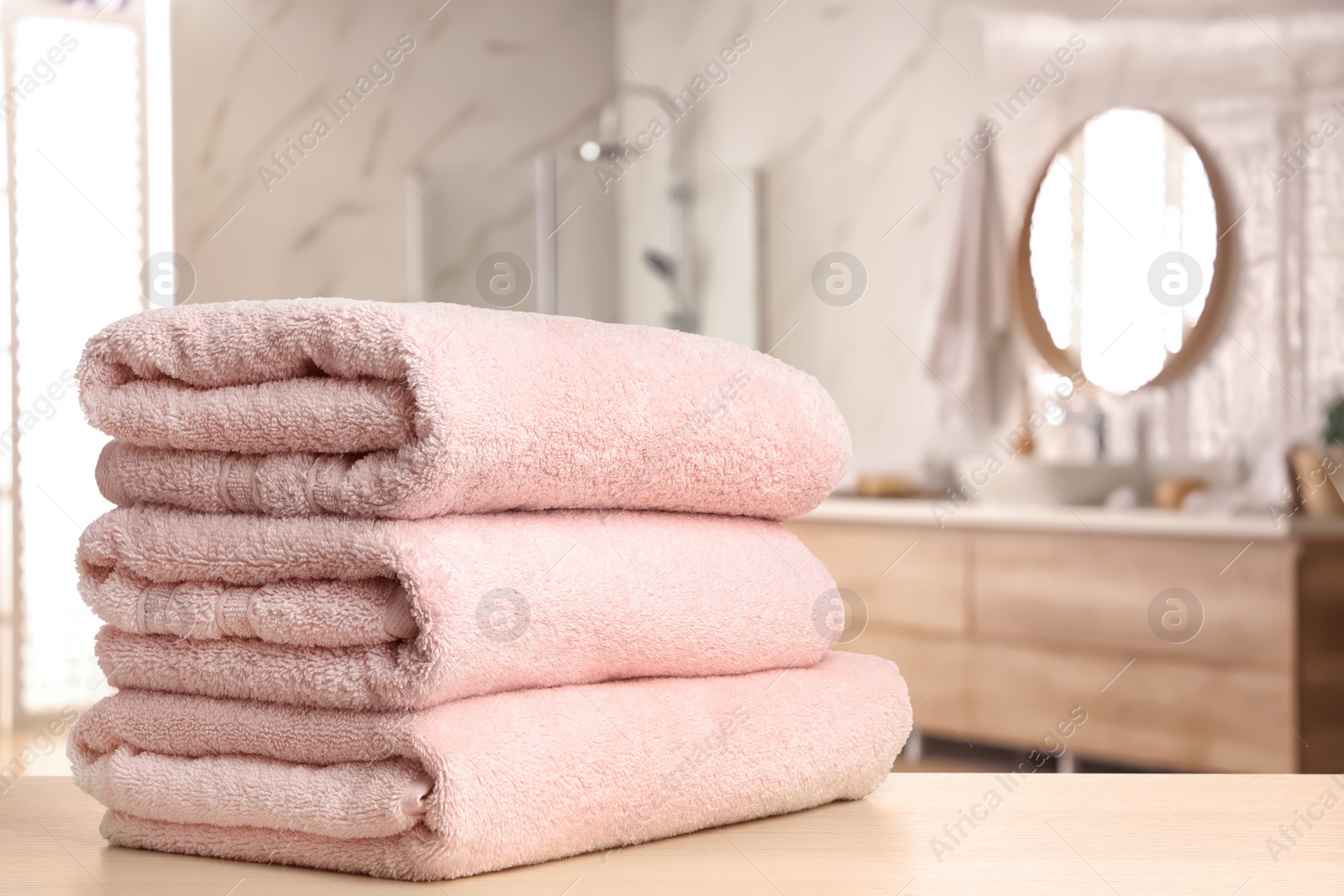 Image of Fresh towels on wooden table in bathroom