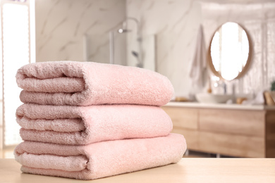 Image of Fresh towels on wooden table in bathroom