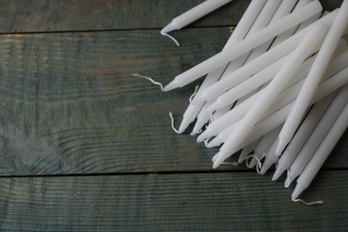 Photo of Many church wax candles on old wooden table, flat lay. Space for text