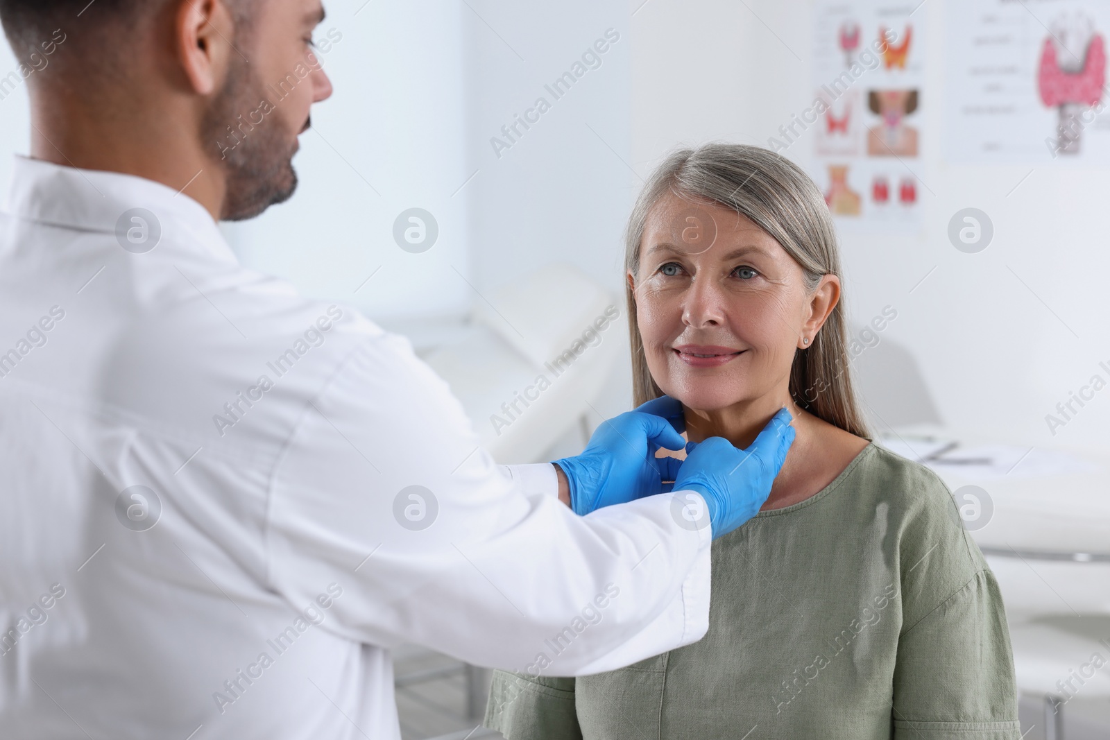 Photo of Endocrinologist examining thyroid gland of patient at hospital, closeup