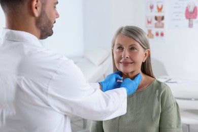 Endocrinologist examining thyroid gland of patient at hospital, closeup