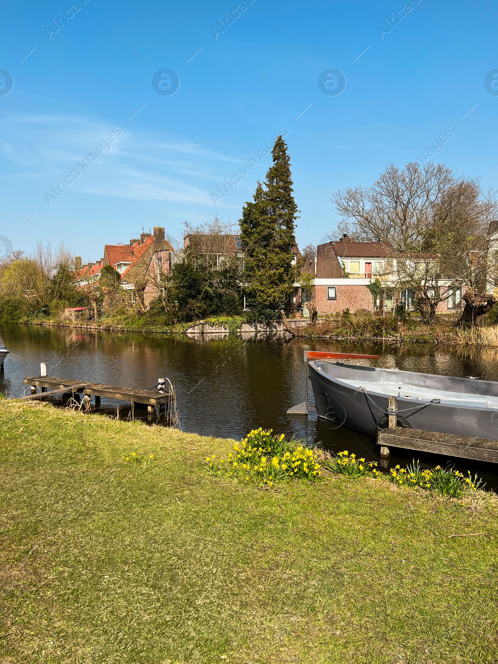 Photo of Beautiful city canal with moored boat on sunny spring day