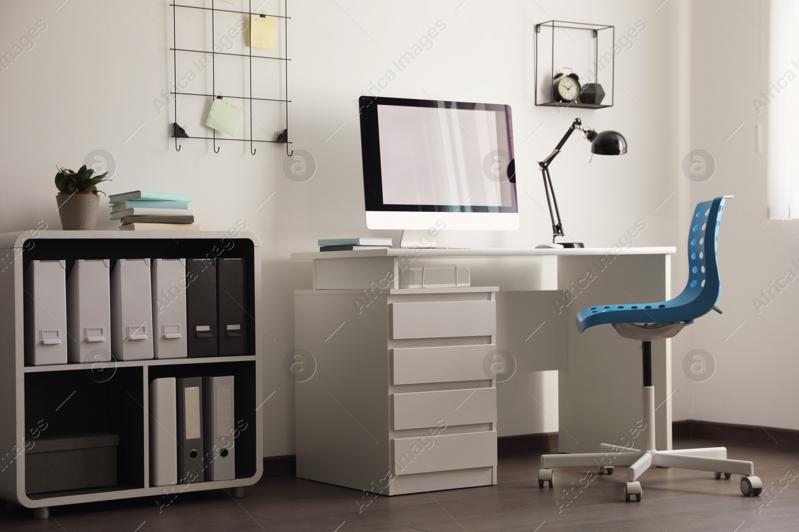 Photo of Comfortable blue chair near desk in stylish office interior