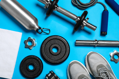 Photo of Gym equipment on light blue background, flat lay