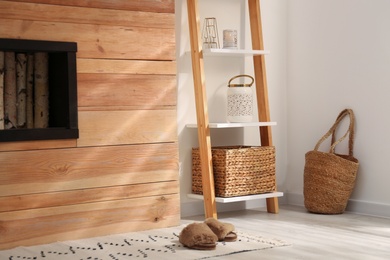 Stylish room interior with wooden ladder near white wall