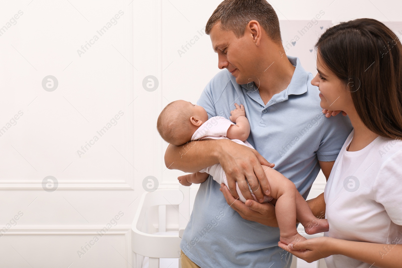 Photo of Happy family with their sleeping baby at home. Space for text