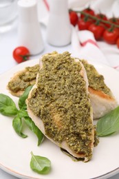 Photo of Delicious chicken breasts with pesto sauce and basil on table, closeup