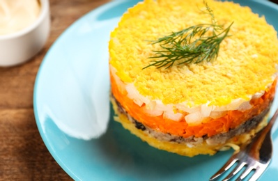 Photo of Traditional russian salad Mimosa served on wooden table, closeup