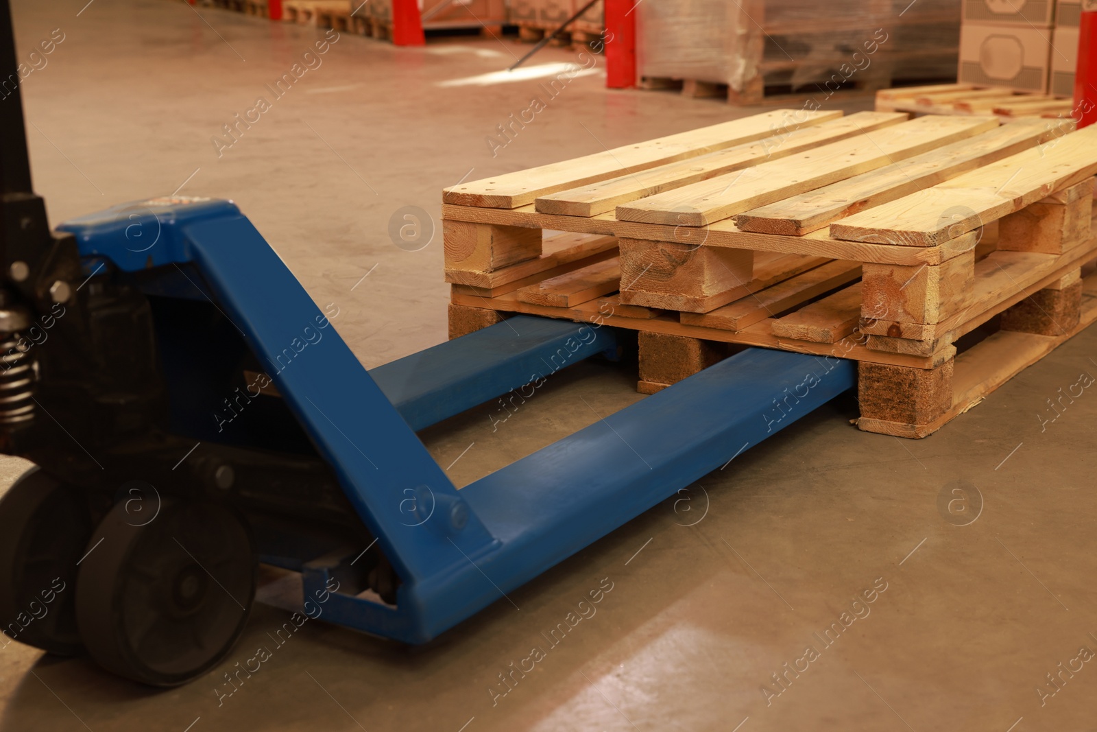 Image of Modern manual forklift with wooden pallets in warehouse, closeup