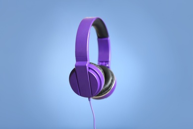 Stylish headphones with pads on color background