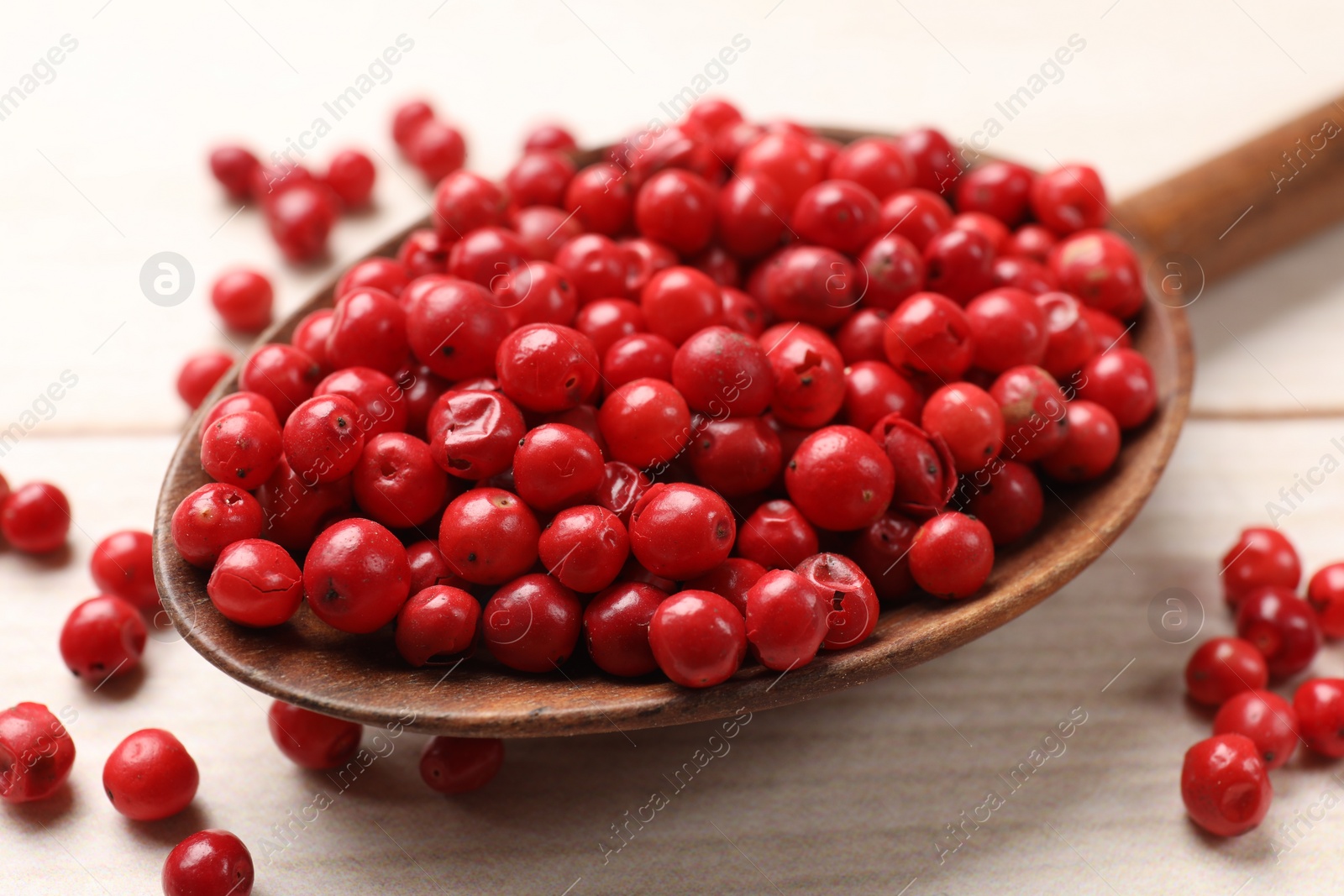 Photo of Aromatic spice. Red pepper in spoon on white wooden table, closeup