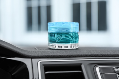 Photo of Stylish air freshener on dashboard in car