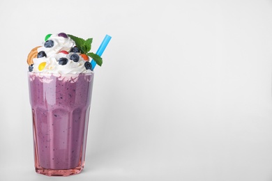 Tasty blueberry milk shake in glass on white background