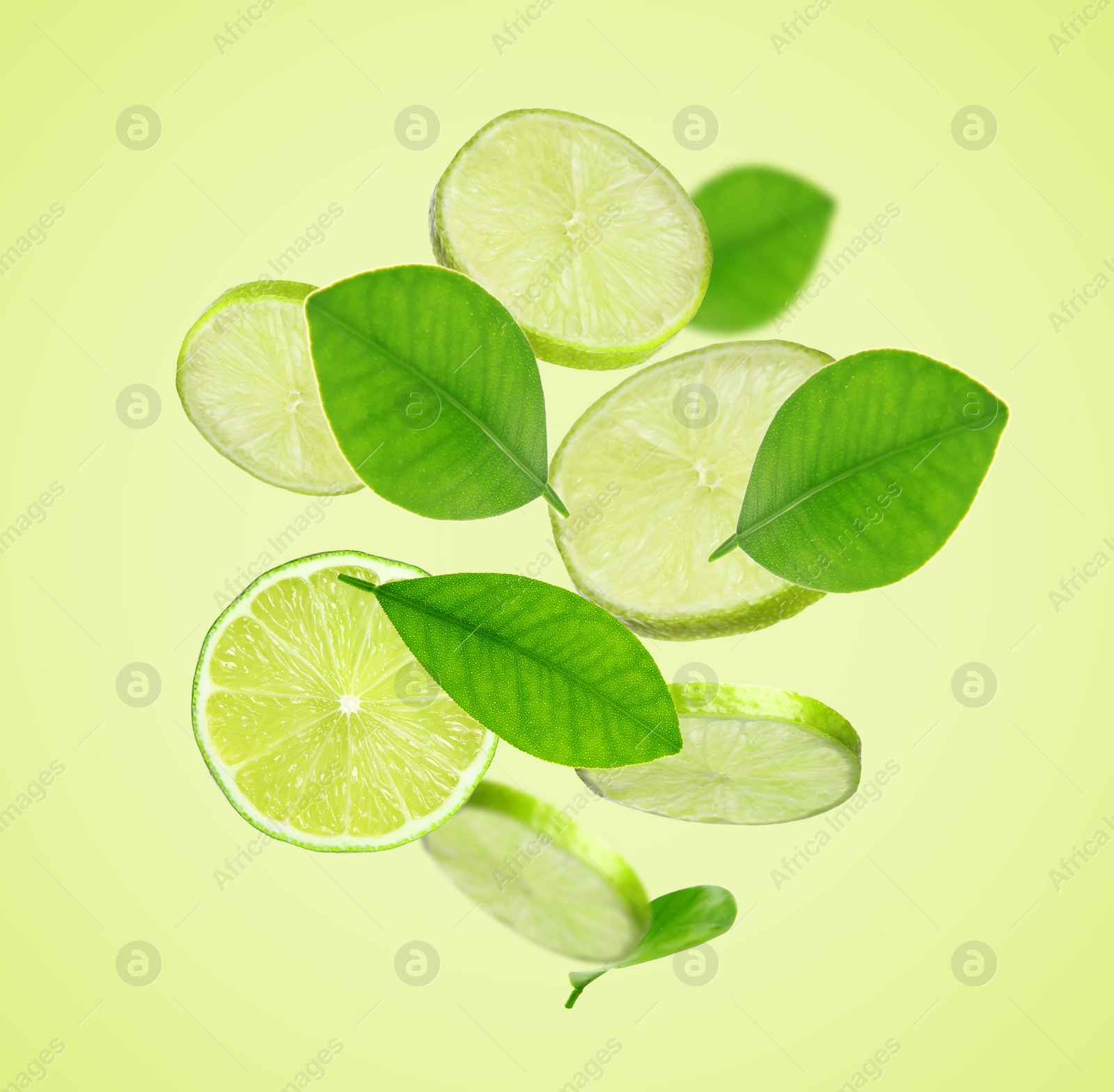 Image of Fresh lime slices and leaves falling on yellow green background