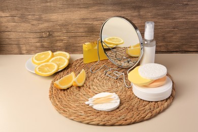 Lemon face cleanser. Fresh citrus fruits, personal care products and mirror on beige table