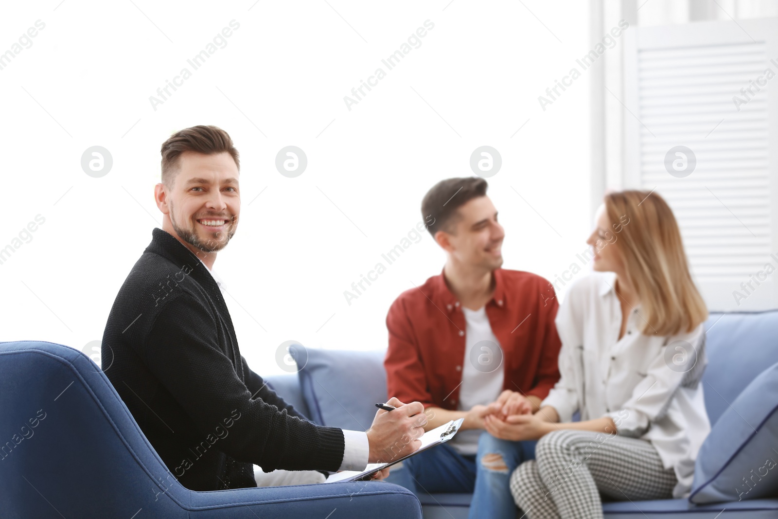 Photo of Young happy couple after therapy session with family psychologist indoors