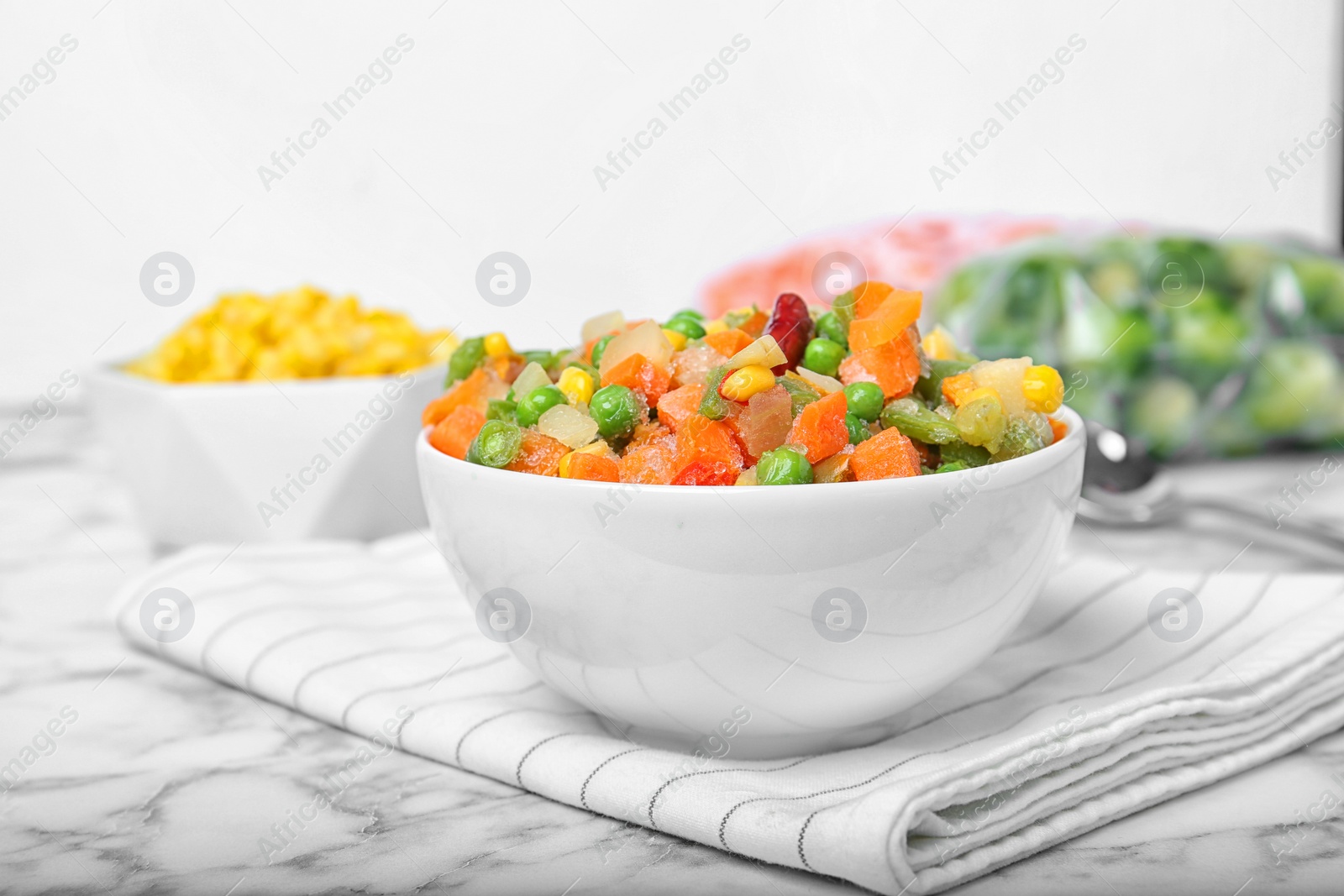 Photo of Bowl with mix of frozen vegetables on table