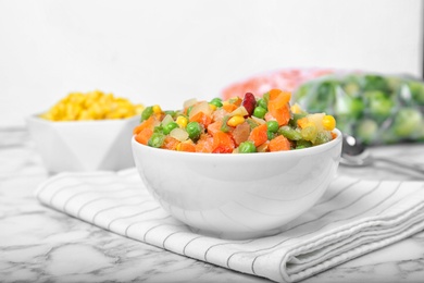 Photo of Bowl with mix of frozen vegetables on table