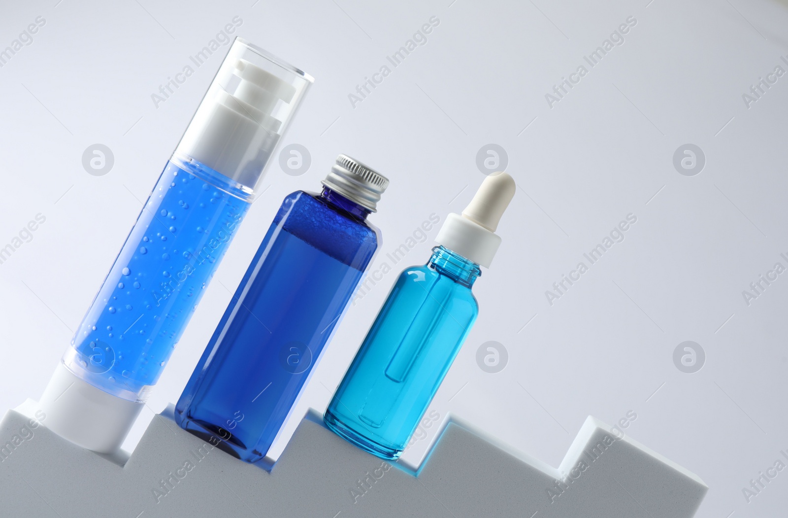 Photo of Set of luxury cosmetic products on stairs against white background