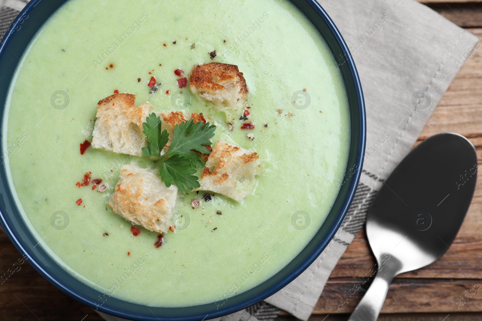 Photo of Delicious asparagus soup with croutons on table, flat lay
