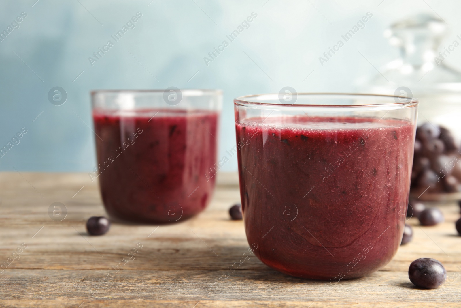 Photo of Glasses with delicious acai smoothie on wooden table, closeup