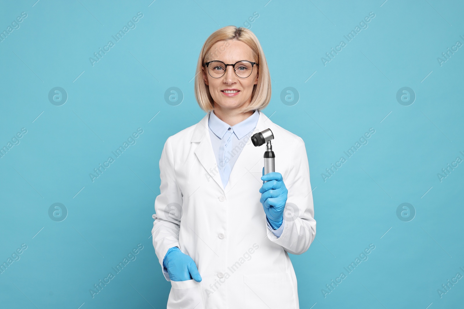 Photo of Dermatologist with dermatoscope on light blue background