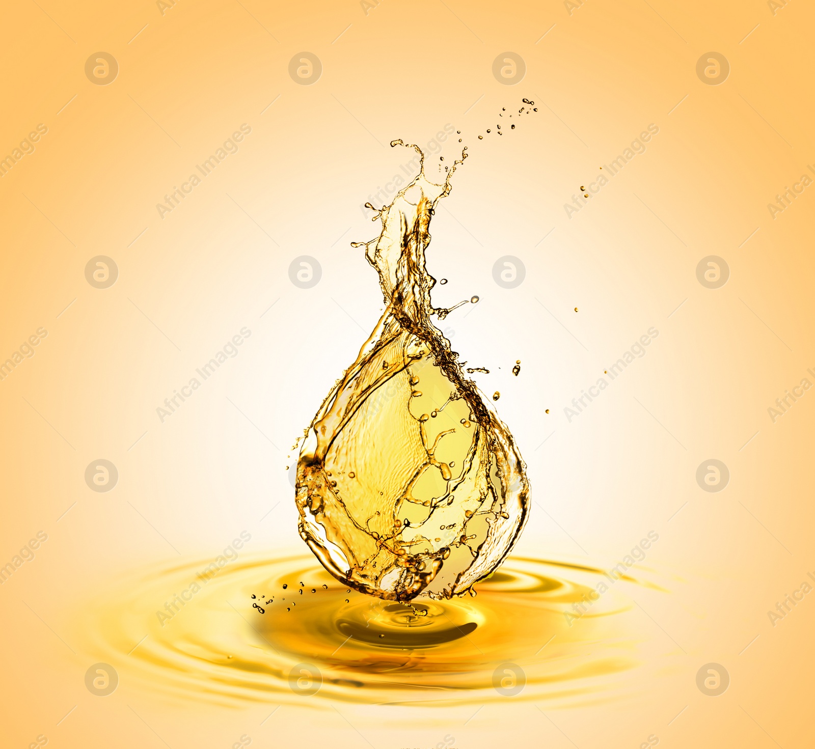 Image of Drop of cooking oil falling into oil on orange gradient background