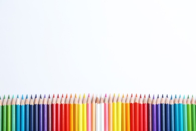 Photo of Composition with color pencils on white background, flat lay. Space for text