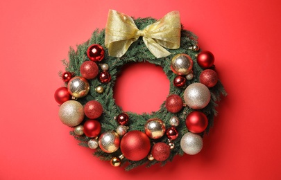 Photo of Beautiful Christmas wreath with festive decor on red background