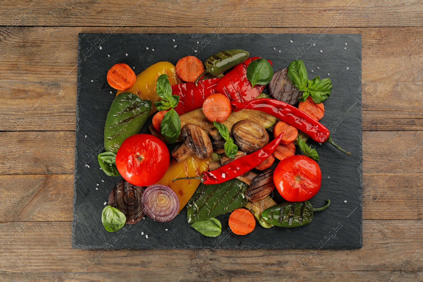 Photo of Delicious grilled vegetables on wooden table, top view