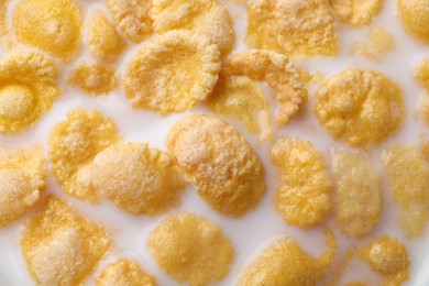 Photo of Tasty cornflakes with milk as background, closeup