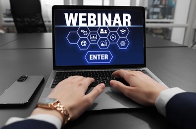 Image of Online webinar, web page on computer screen. Woman using laptop at black table, closeup