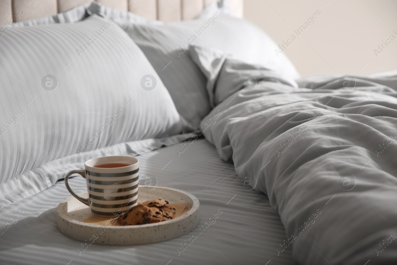 Photo of Tray with breakfast and soft blanket on bed