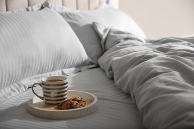 Tray with breakfast and soft blanket on bed