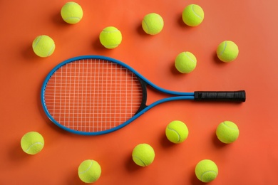Photo of Tennis racket and balls on orange background, flat lay. Sports equipment