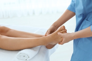 Photo of Woman receiving leg massage in wellness center, closeup