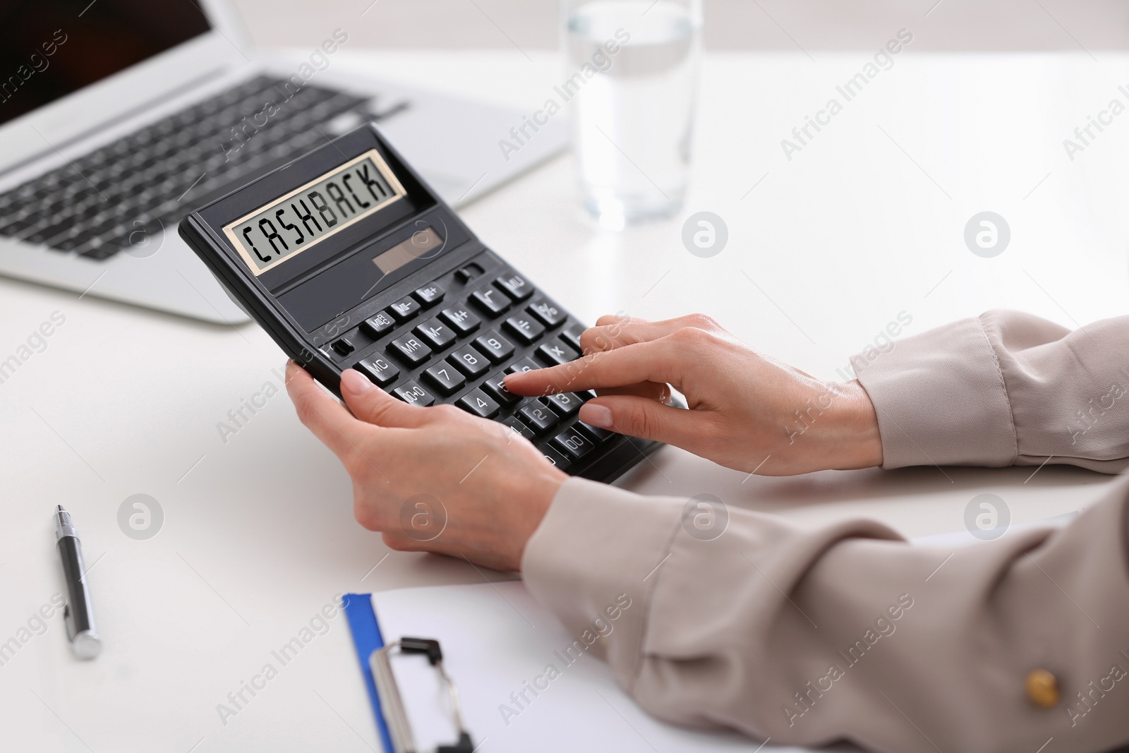 Image of Cashback. Woman using calculator at workplace, closeup