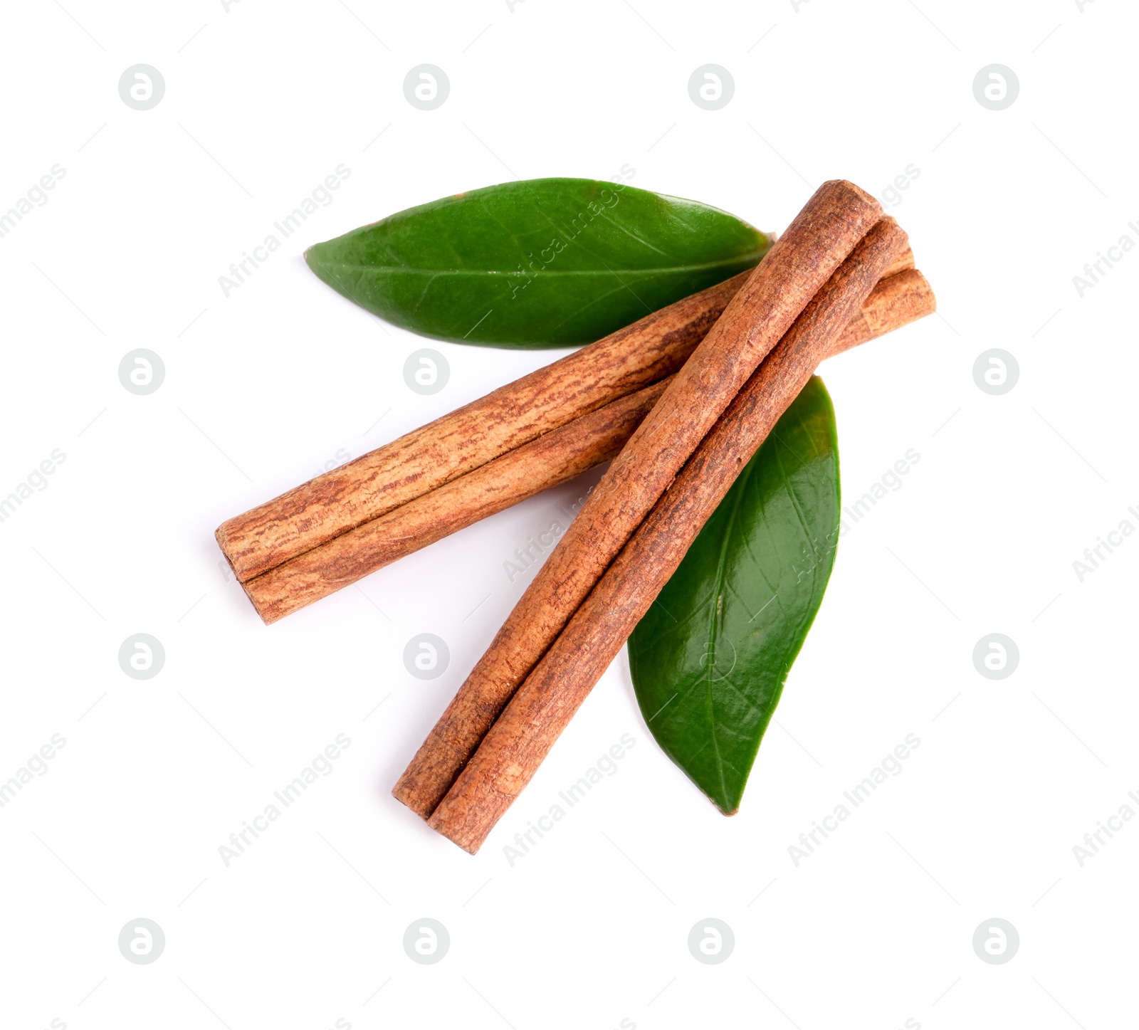 Photo of Cinnamon sticks and green leaves isolated on white, top view