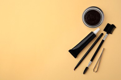 Photo of Flat lay composition with eyebrow henna and tools on beige background. Space for text