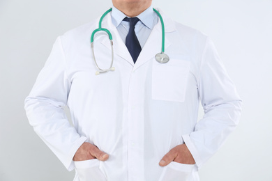 Photo of Senior doctor with stethoscope on white background, closeup