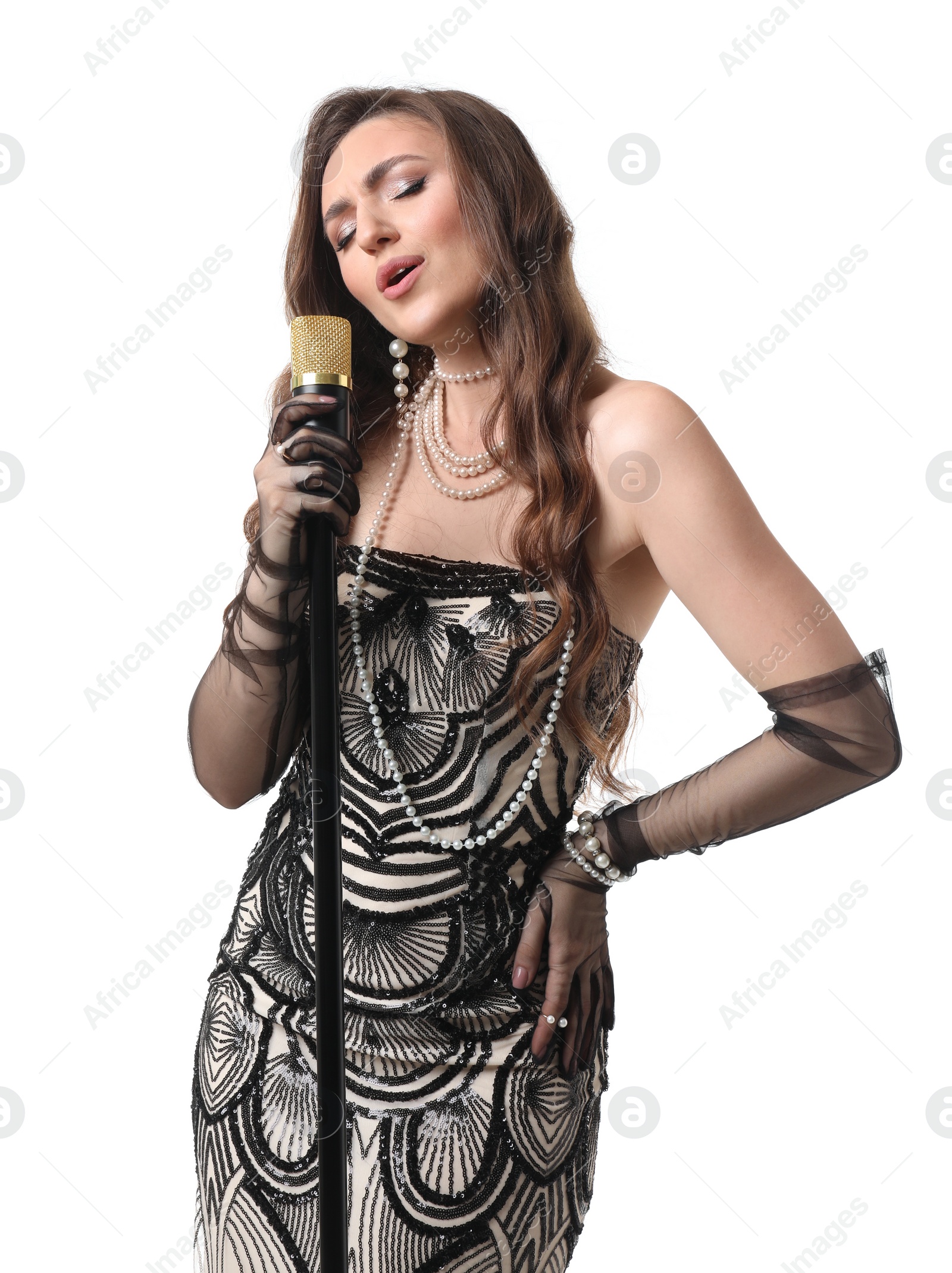 Photo of Beautiful young woman in stylish dress with microphone singing on white background