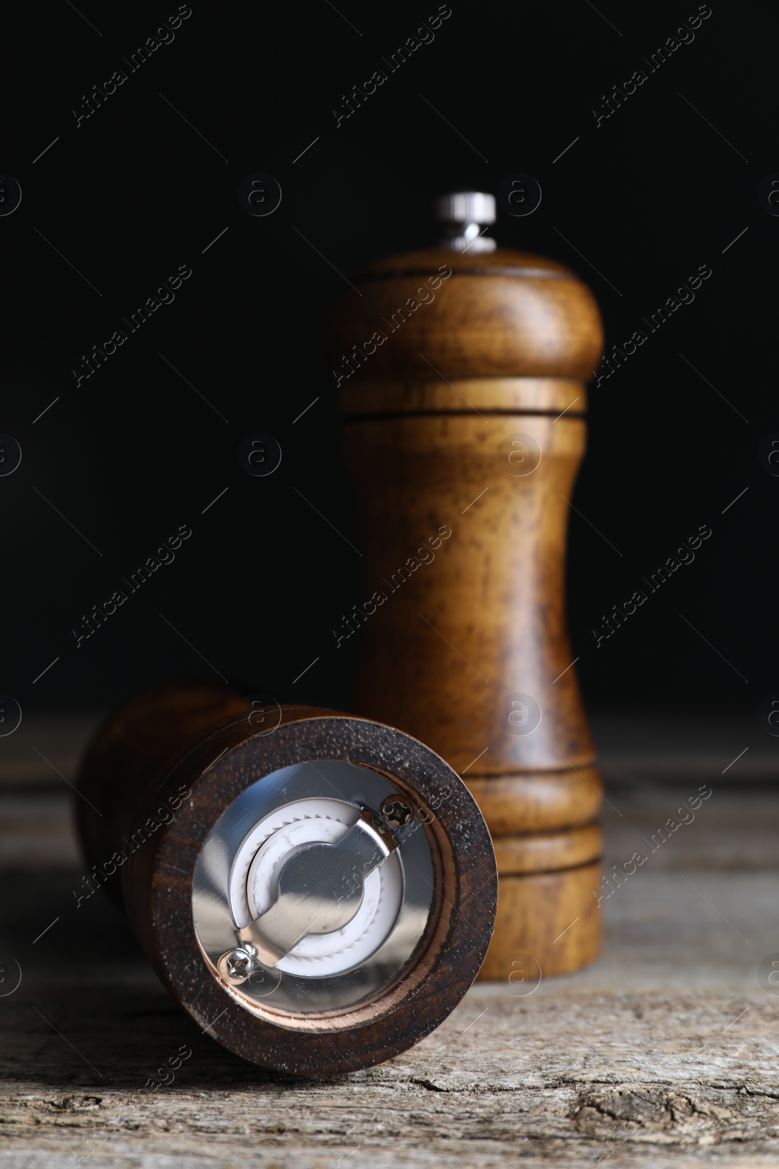 Photo of Salt and pepper shakers on wooden table, closeup