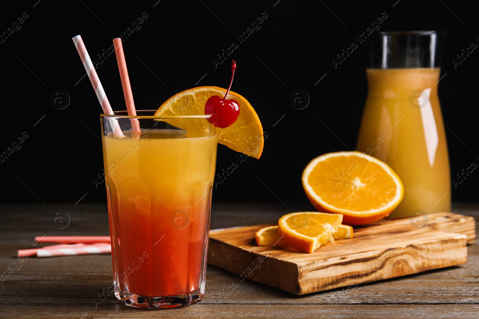 Photo of Fresh alcoholic Tequila Sunrise cocktail on wooden table
