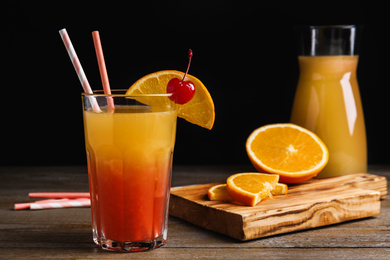 Photo of Fresh alcoholic Tequila Sunrise cocktail on wooden table