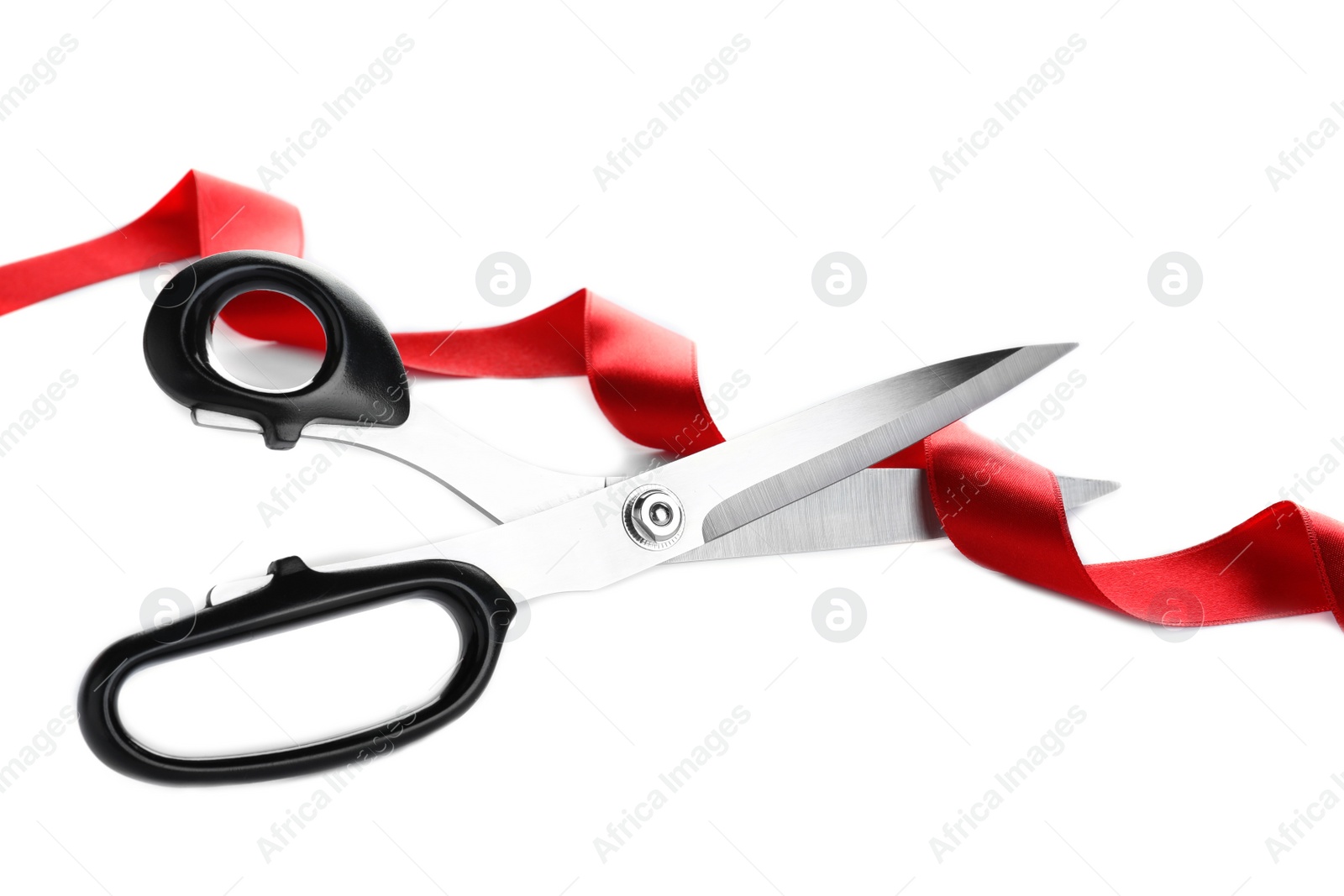 Photo of Stylish scissors and red ribbon on white background. Ceremonial tape cutting