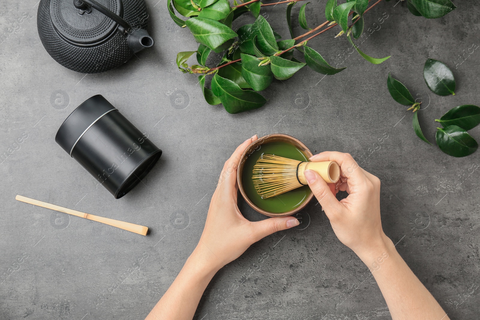 Photo of Woman preparing matcha tea at table, top view