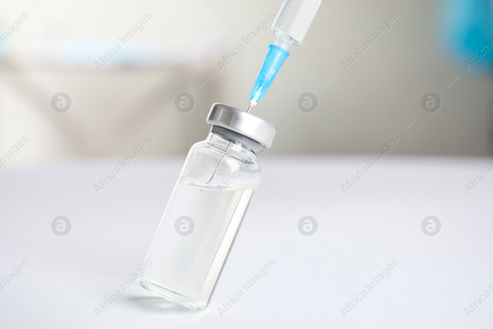 Photo of Vial and syringe on blurred background. Vaccination and immunization