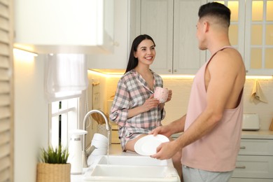 Photo of Happy couple wearing pyjamas and spending time together in kitchen